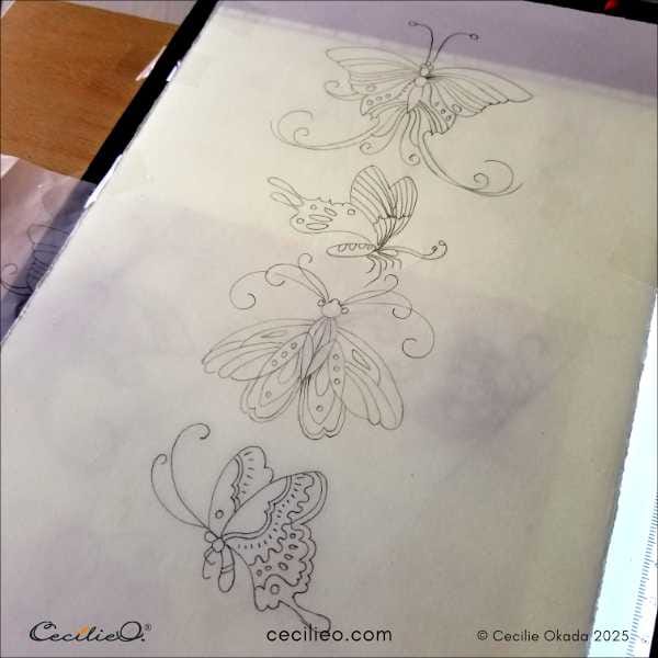 Tracing butterflies onto watercolor paper, using a LED-light tracing pad.
