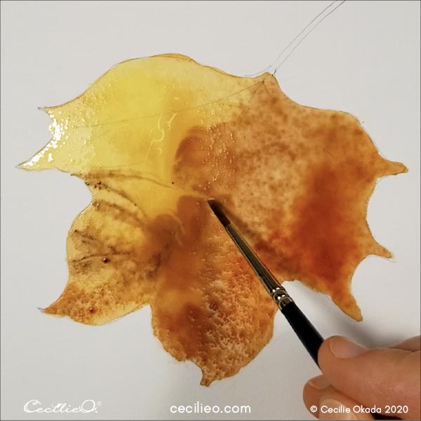 Painting the leaf with watercolor.